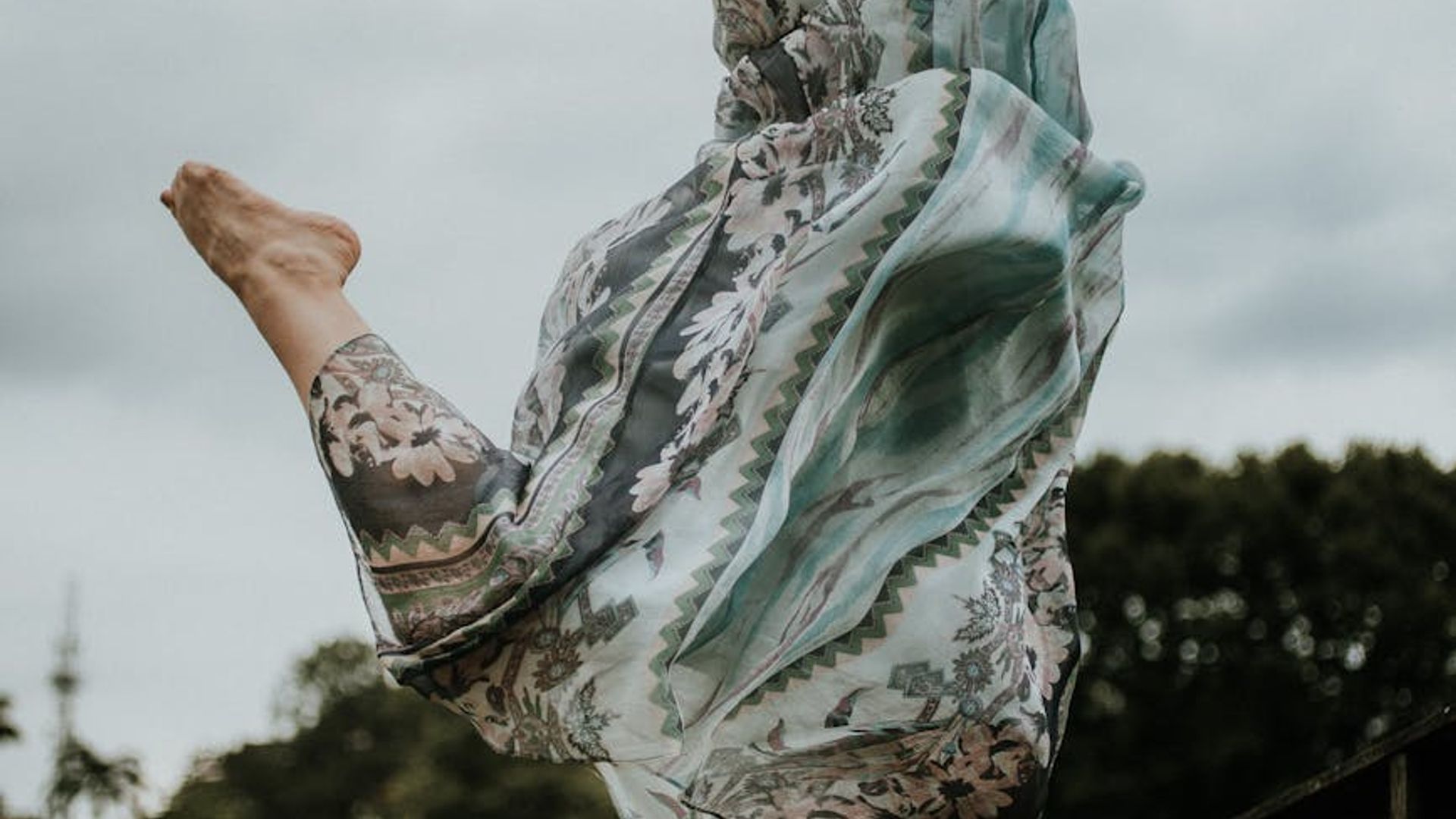 A person performing light movements in a bright airy room.